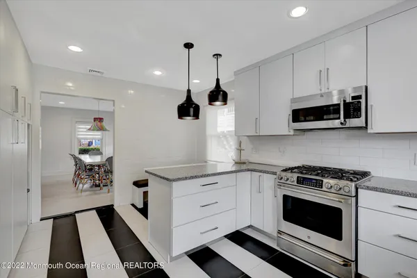 a kitchen with stainless steel appliances kitchen island granite countertop a stove a sink and a microwave