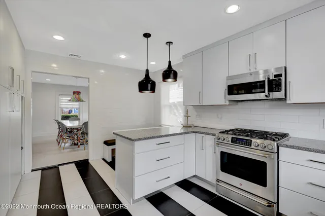 a kitchen with stainless steel appliances kitchen island granite countertop a stove a sink and a microwave