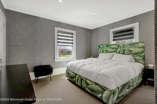 a bedroom with a bed chair and a window