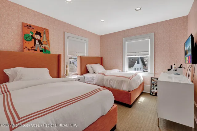 a bedroom with two beds and painting on the wall