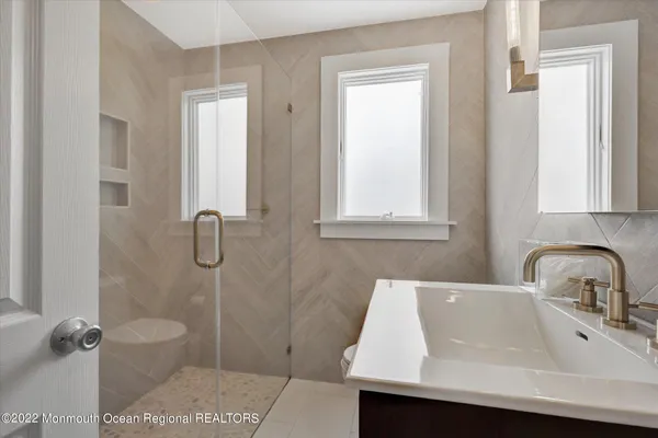 a bathroom with a sink a toilet and shower