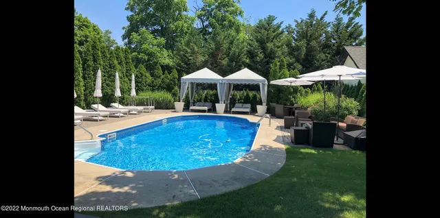 swimming pool view with a seating space and garden