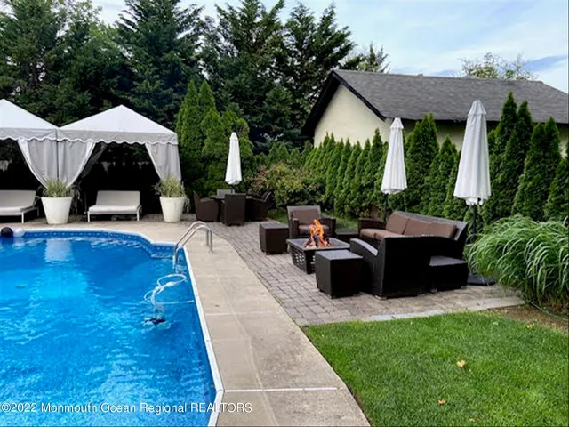 a view of a patio with table and chairs potted plants and a palm tree