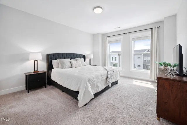 a spacious bedroom with a bed and a flat screen television