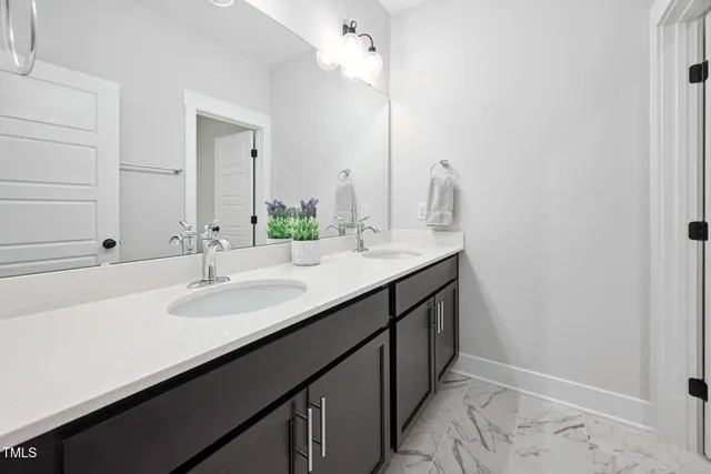 a bathroom with a double vanity sink and a mirror