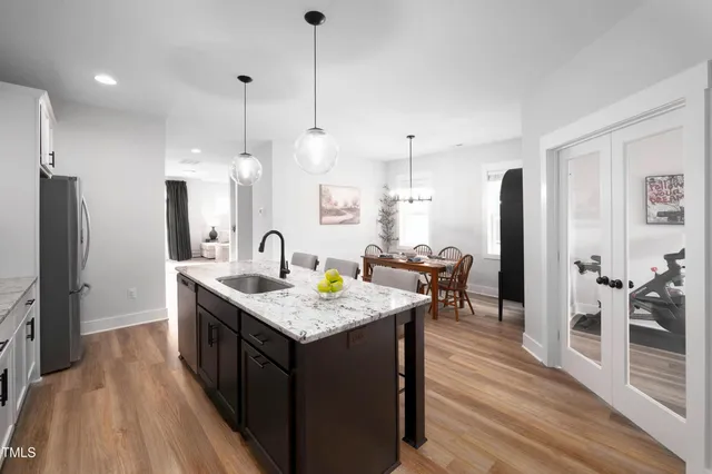 a open kitchen with stainless steel appliances granite countertop a sink a stove and a refrigerator