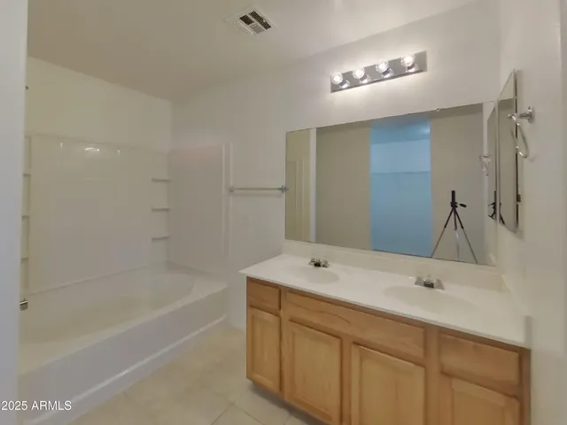 an empty room with windows and ceiling fan