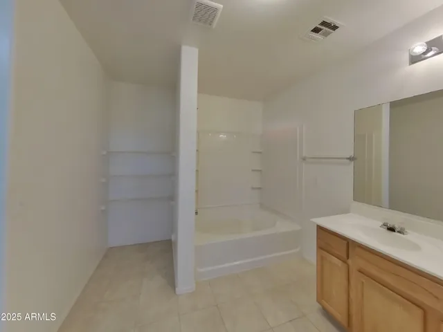 a bathroom with a tub sink and mirror