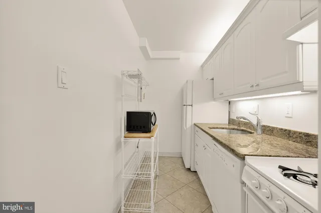 a bathroom with a granite countertop sink and a white cabinets