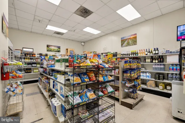 a view of a hallway with wooden floor and a bathroom