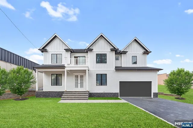 a front view of a house with a garden and yard