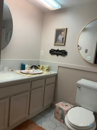a bathroom with a toilet a sink and mirror