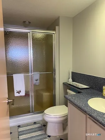 a bathroom with a granite countertop sink toilet and shower