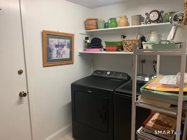 a utility room with a refrigerator and cabinets