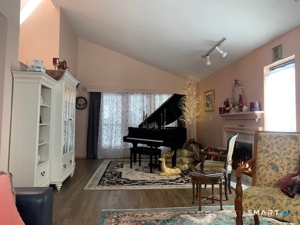 a living room with furniture a piano and a fireplace