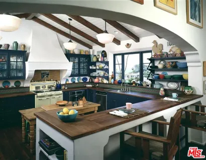 a kitchen with a sink a stove and chairs