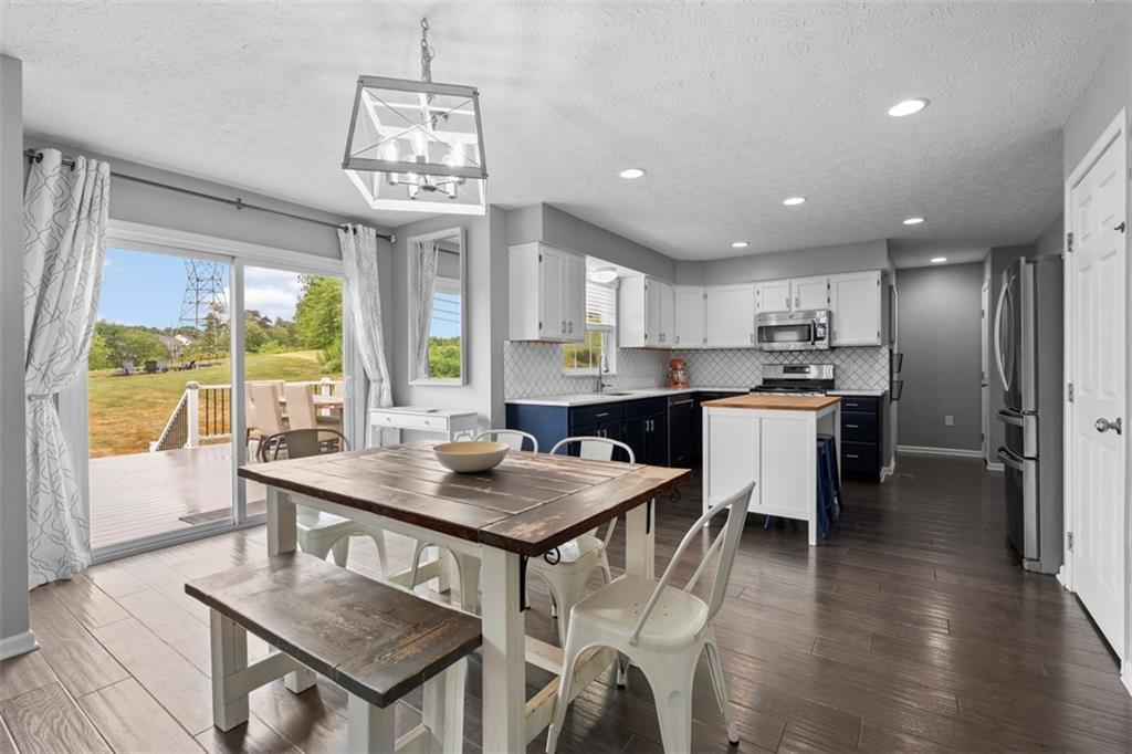 145 Brighton Lane Mars, PA 16046 - Photo 14 of 44 a view of a dining room with furniture a chandelier and wooden floor