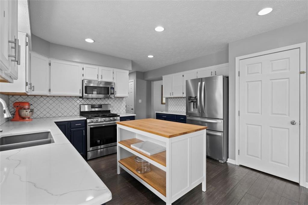 145 Brighton Lane Mars, PA 16046 - Photo 19 of 44 a kitchen with stainless steel appliances granite countertop a refrigerator a stove top oven a sink and dishwasher with wooden floor