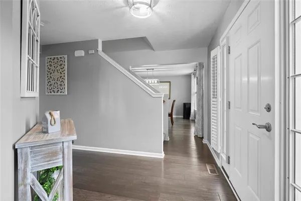a view of a hallway with wooden floor and staircase
