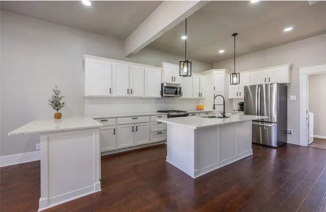 a kitchen with stainless steel appliances granite countertop a sink a stove and cabinets