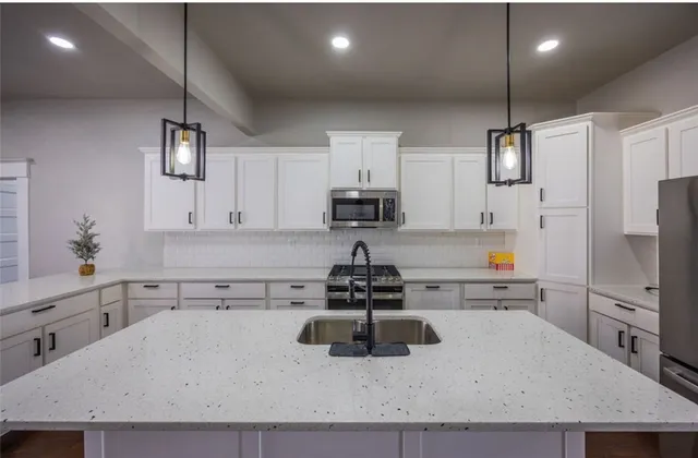 a stove sitting inside of a kitchen with white cabinets