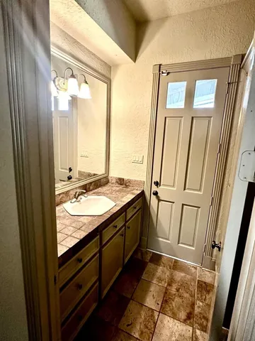 a bathroom with a granite countertop sink and a mirror