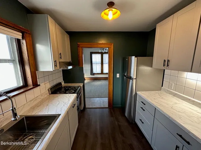 a view of an empty room with a fireplace and a window