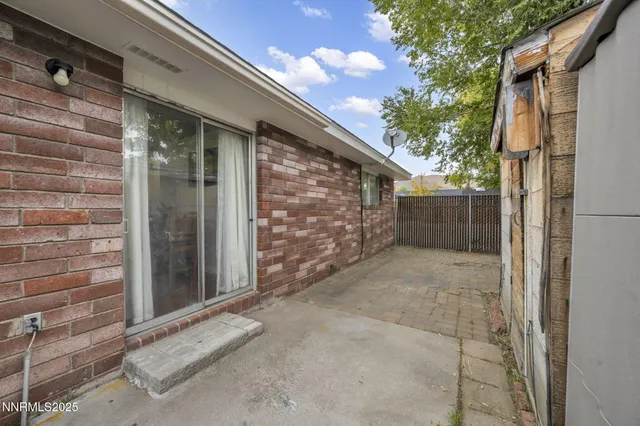 a view of backyard with wooden fence and a large tree