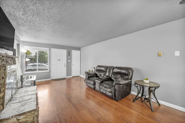 a living room with furniture a flat screen tv and a fireplace