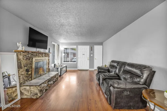 a living room with furniture a flat screen tv and a fireplace