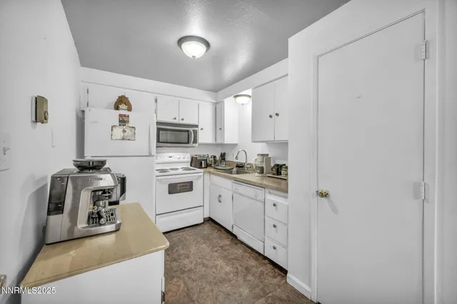 a kitchen with white cabinets and white appliances