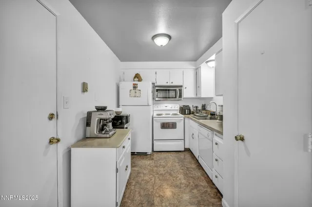 a kitchen with stainless steel appliances granite countertop white cabinets and a sink
