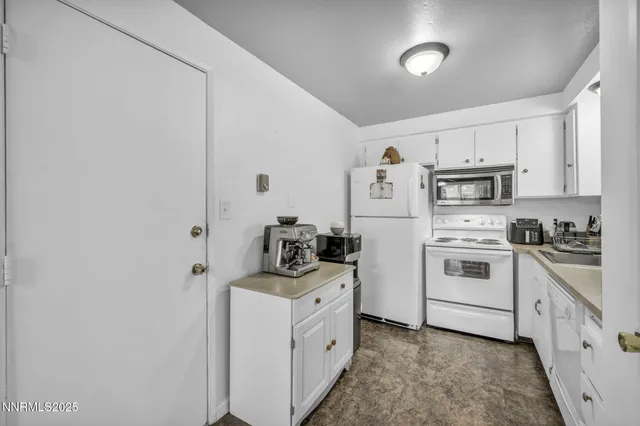 a kitchen with stainless steel appliances granite countertop a stove and white cabinets