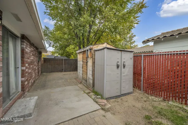 a view of a small house with wooden fence