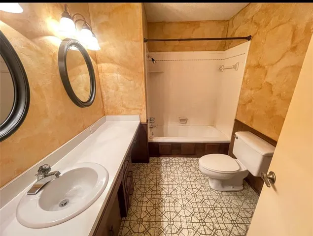 a bathroom with a sink toilet and a mirror