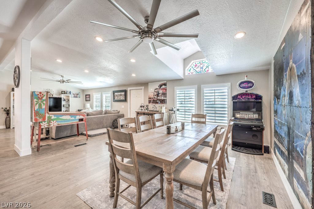 4375 Pinwheel Street Logandale, NV 89021 - Photo 14 of 52 An inviting open-concept area features a dining space seamlessly flowing into a living room, accented by a distinctive skylight.
