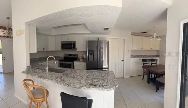 a kitchen with a refrigerator sink and cabinets