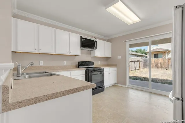 a kitchen with a stove a sink and a refrigerator