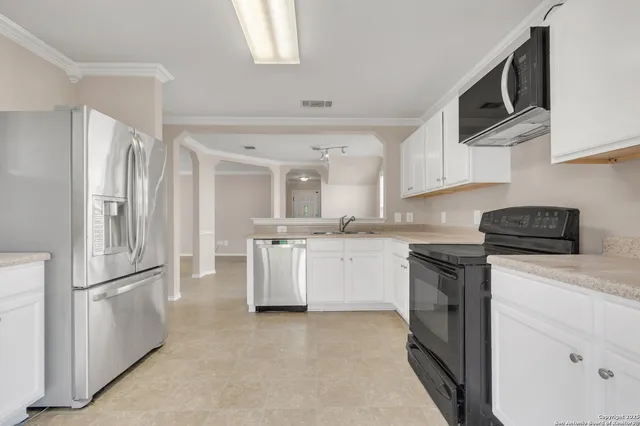 a kitchen with white cabinets and white appliances
