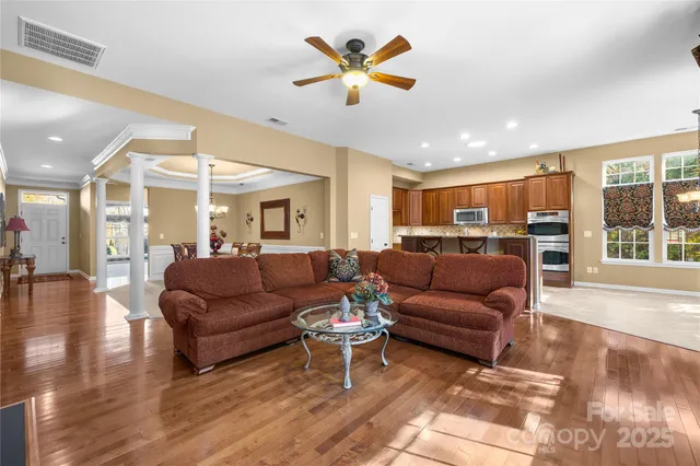 a living room with furniture ceiling fan and a large window