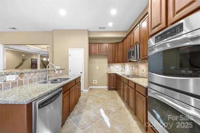 a kitchen with stainless steel appliances granite countertop a sink and a stove