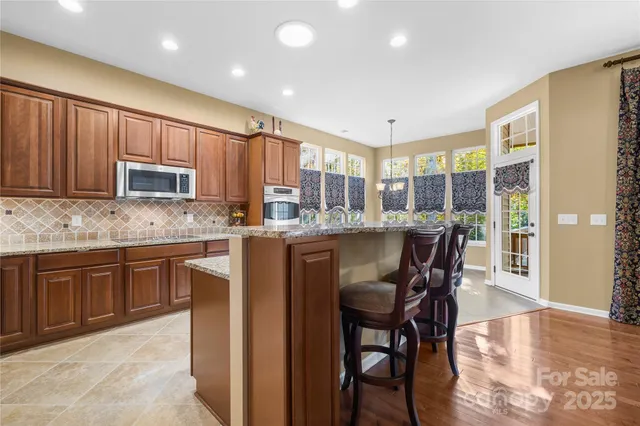 a kitchen with granite countertop wooden cabinets and stainless steel appliances