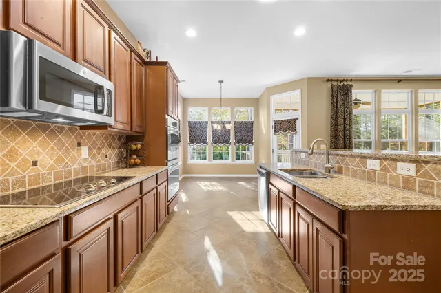 a large kitchen with kitchen island granite countertop a large window and a sink
