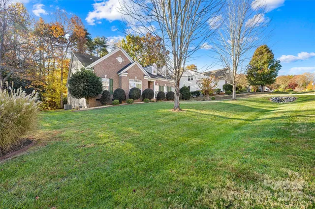 a front view of a house with a yard and trees