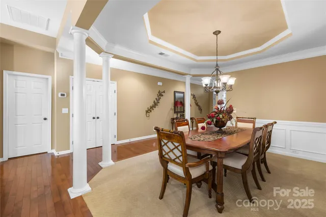 a view of a dining room with furniture wooden floor and chandelier