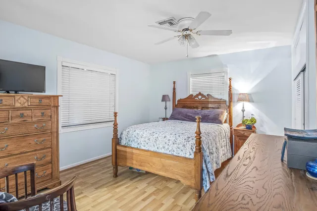a bedroom with a bed and wooden floor