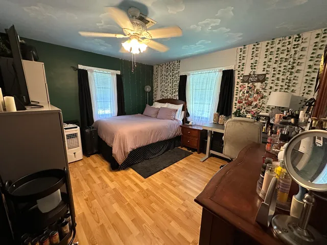 a bedroom with a bed mirror and window