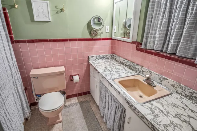 a bathroom with a granite countertop toilet and a sink