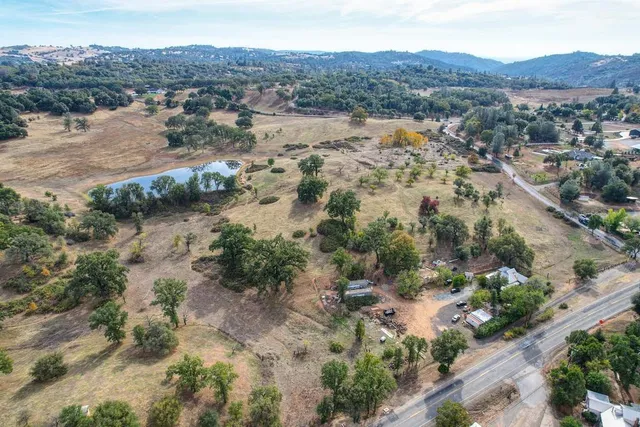 an aerial view of mountain with residential house and lake view