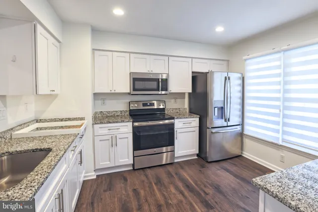 a kitchen with a stove a sink and a refrigerator